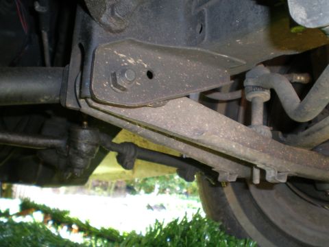 1966 Ford Mustang - Close-up of a vehicle's suspension system, showing various metal linkages and components.