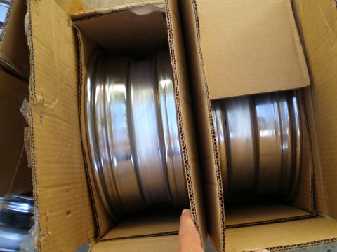1966 Ford Mustang - Several chrome wheels are packed in cardboard boxes, ready for shipping or storage.