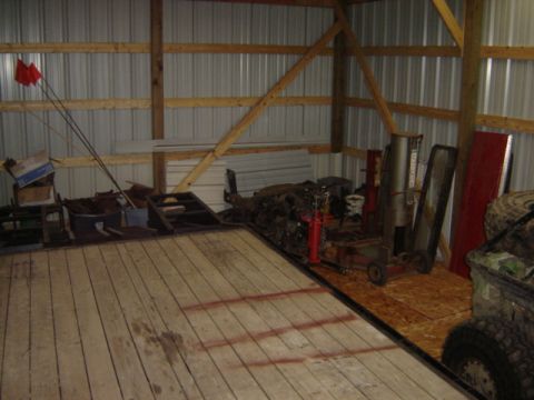 1992 Ford Bronco - The interior of a barn is shown, filled with various stored items and equipment, with a Supermotors.net logo visible in the lower right cor…