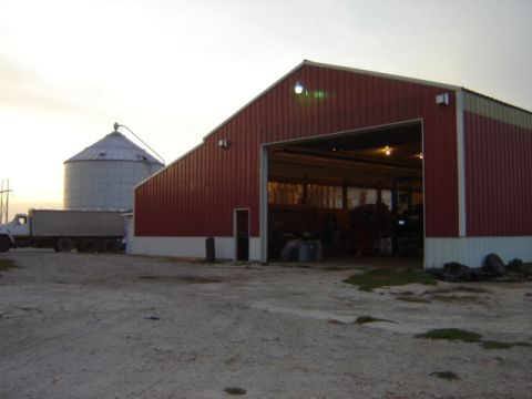 1992 Ford Bronco - A truck sits beside a large red barn, with a silo visible in the distance under a pale sky.