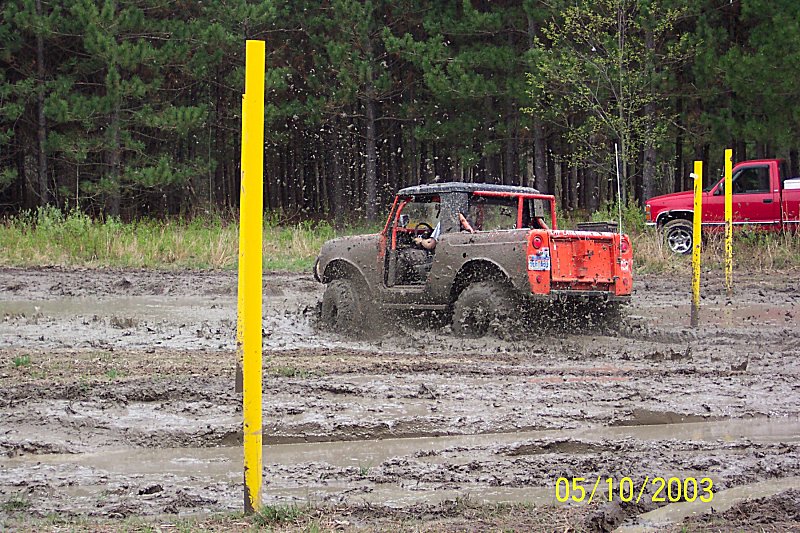 1978 Ford Bronco in mud, rear view. Orange tailgate