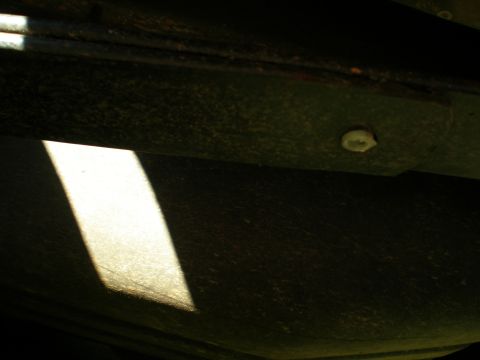 1966 Ford Mustang - A close-up view of the undercarriage of a vehicle, showing structural elements and a distinct light pattern.
