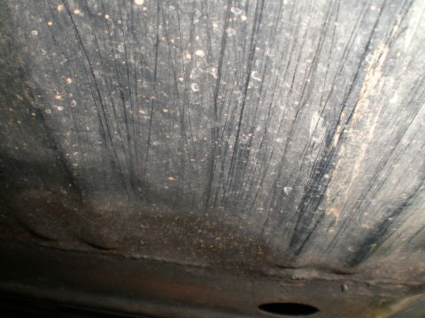 1966 Ford Mustang - The underside of a vehicle shows scuff marks and dirt accumulation, with a visible circular opening.