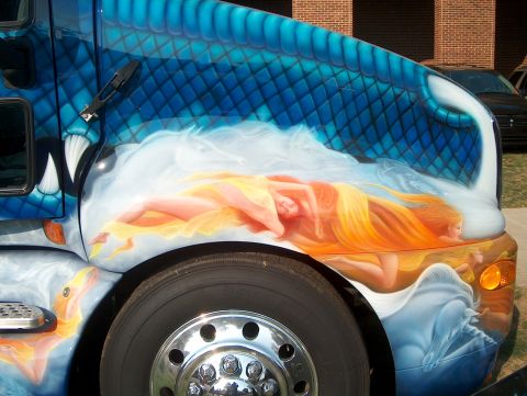 1978 Ford Bronco - Airbrushed artwork of a dragon and mythical figures adorns the side of a truck, with a large chrome wheel in the foreground.