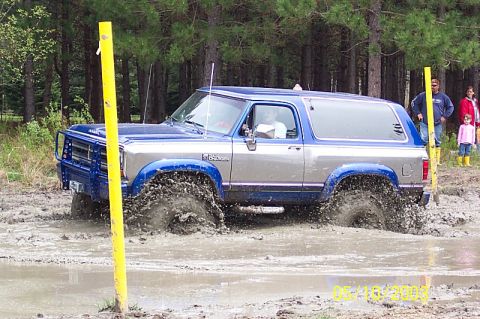 1978 Ford Bronco - This two-tone SUV navigates a muddy obstacle course, kicking up significant spray. The vehicle's body style suggests an early 1980s model,…