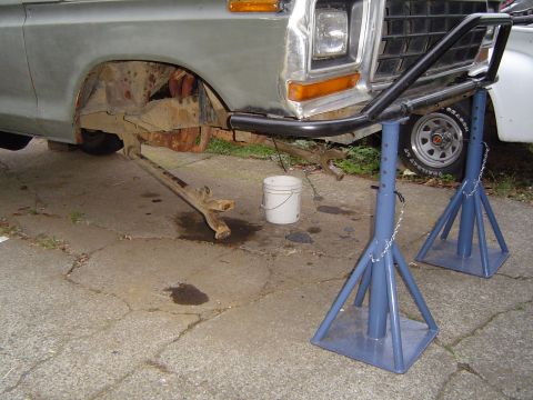 1978 Ford Bronco - Front suspension removed from a 1970s Ford truck, which is supported by jack stands.