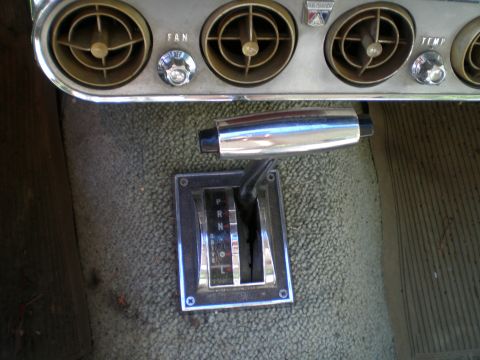 1966 Ford Mustang - The interior of a 1966 Ford Mustang features an automatic transmission shifter and air vents on the dashboard.