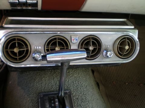 1966 Ford Mustang - Close-up of a 1966 Ford Mustang's interior, showing the center console with air vents and controls.