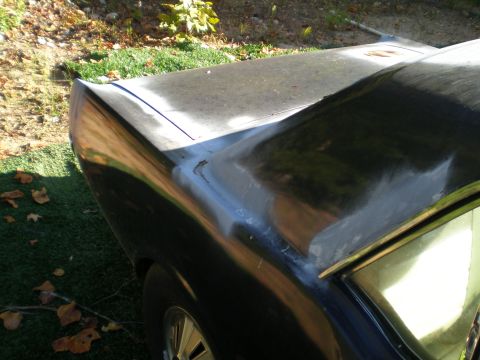 1966 Ford Mustang - The rear of a black 1966 Ford Mustang is shown with visible bodywork and primer.