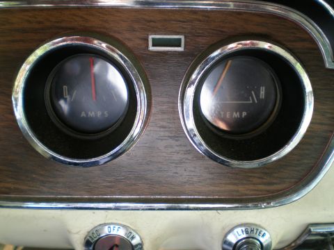 1966 Ford Mustang - Close-up of the 1966 Ford Mustang's dashboard, the ammeter and temperature gauges with wood grain trim.