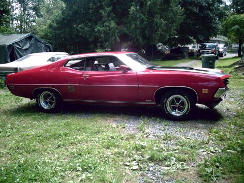 1970 Ford Torino - This red 1970 Ford Torino GT coupe features distinctive side trim and black hood stripes.