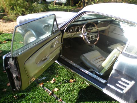 1966 Ford Mustang - The interior of a classic Ford Mustang shows its age with worn seats and a vintage dashboard.