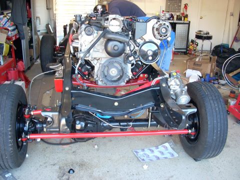 1992 Ford Bronco - Front suspension and engine assembly of a vehicle undergoing work in a garage.