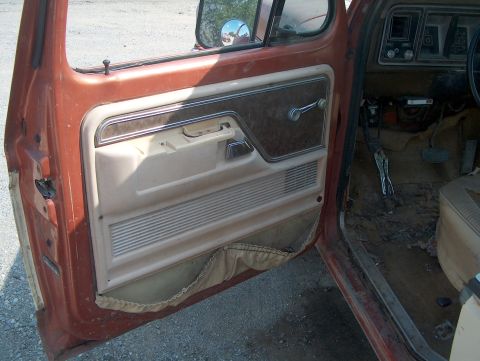 1979 Ford F-250 - The interior of a 1979 Ford F-250 shows a worn door panel and dashboard.