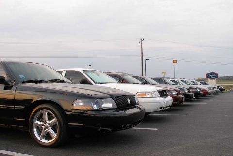 2001 Ford Crown Victoria - A line of Mercury Marauders are parked in a lot, with a black model in the foreground.