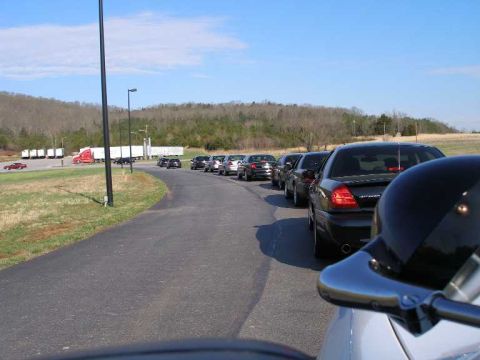 2001 Ford Crown Victoria - A convoy of Ford Crown Victorias is seen from the rear, parked on a road with a truck stop in the background.