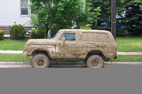 1978 Ford Bronco - This 1978 Ford Bronco is heavily covered in mud, obscuring its original appearance.