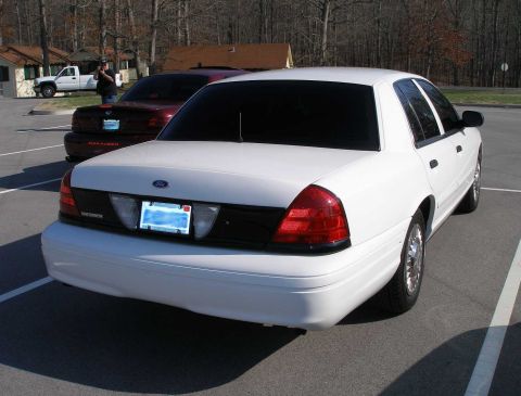 2001 Ford Crown Victoria - A white 2001 Ford Crown Victoria is parked in a lot, with a maroon Marauder visible behind it.