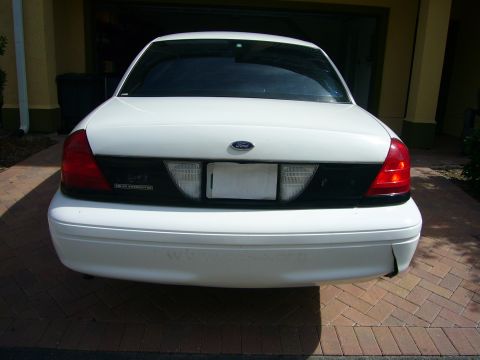 2001 Ford Crown Victoria - The rear of a white Ford Crown Victoria, showing its taillights and Ford emblem.