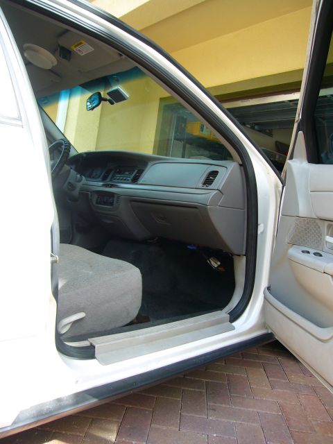 2001 Ford Crown Victoria - The interior of a white 2001 Ford Crown Victoria is visible with the driver's side door open.