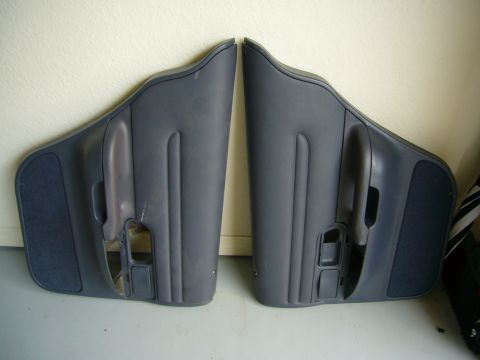2001 Ford Crown Victoria - Two dark blue interior car door panels are displayed side-by-side against a light-colored wall.