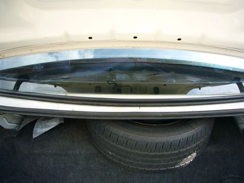 2001 Ford Crown Victoria - The trunk of a car, showing the spare tire and the interior of the rear window.
