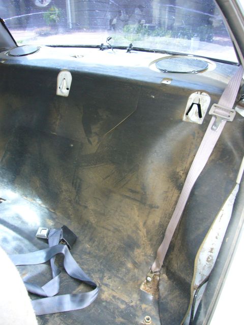 2001 Ford Crown Victoria - The interior rear seat area shows seatbelts and mounting hardware, with a view through the rear window.
