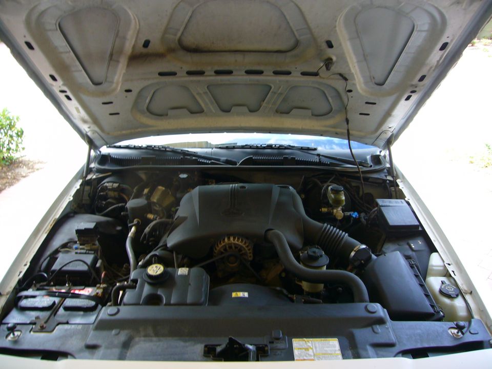 Engine bay of a 2001 Ford Crown Victoria, showing the V8 engine, battery, and air intake system
