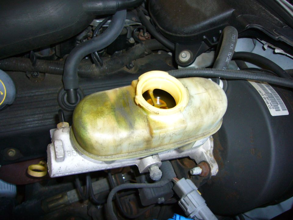 2001 Ford Crown Victoria brake fluid reservoir, yellow cap open, fluid level visible, engine bay detail