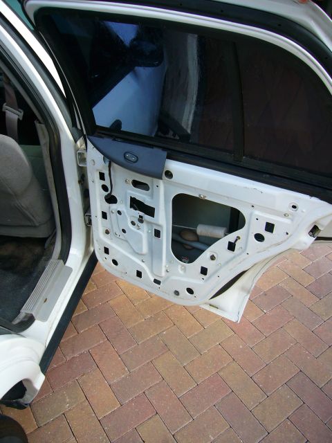 2001 Ford Crown Victoria - The interior of a car door frame, stripped of its panel, reveals the internal workings.