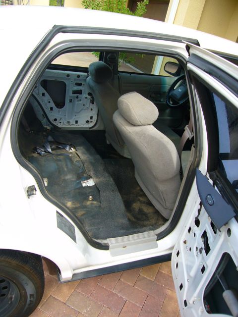 2001 Ford Crown Victoria - The interior of a car is shown with the rear door panels removed, revealing the inner workings.