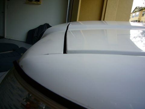 2001 Ford Crown Victoria - Close-up view of a white car's hood and roofline, showing panel gaps.