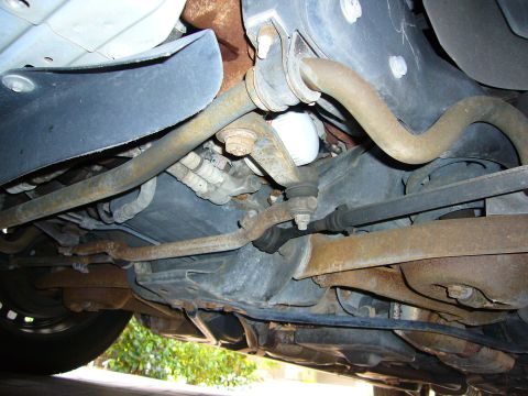 2001 Ford Crown Victoria - The complex network of suspension components and the oil filter are visible from beneath the vehicle.