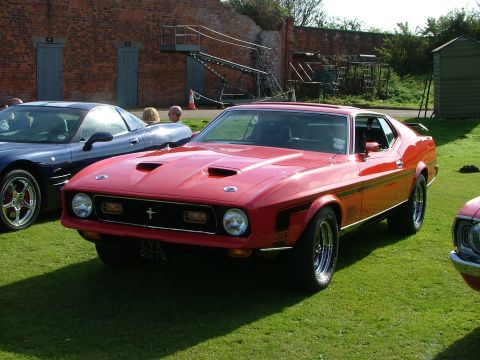 1988 Ford Sport - Front view of a red 1971 Ford Mustang Mach 1 with a blue car beside it.