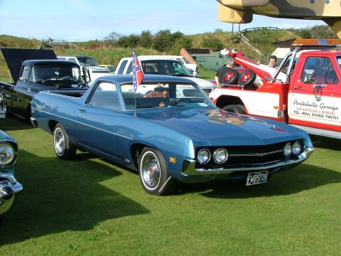 1988 Ford Sport - Blue 1970 Ford Ranchero with Confederate flag on antenna, parked next to a tow truck.