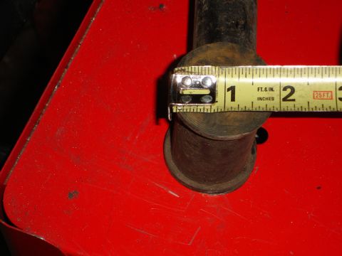 1989 Ford Bronco - Measuring a metal component with a tape measure, indicating its size.