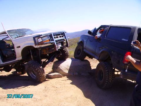 1990 Ford Bronco - Two modified SUVs, including a 1990 Ford Bronco, tackle a challenging off-road obstacle course.