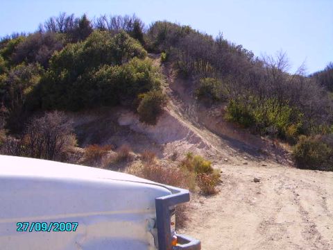 1990 Ford Bronco - A dirt trail ascends a dry, brush-covered hillside on a clear day.