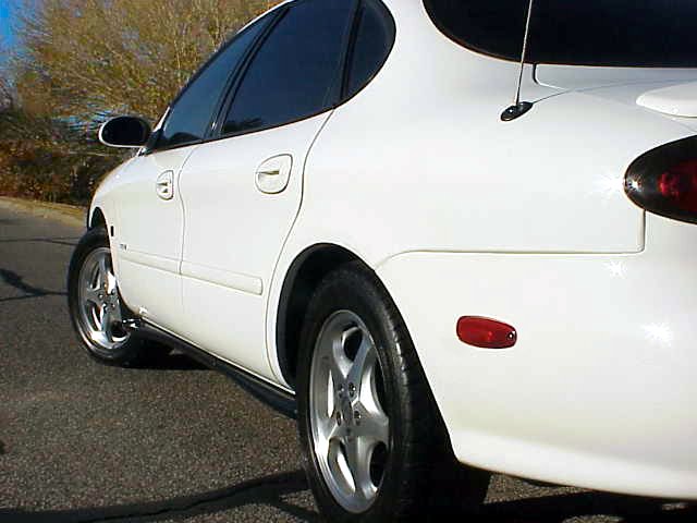 White 1999 Ford Taurus, 3/4 front view showing side and rear quarter panel