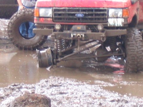1989 Ford Bronco - This truck appears to be stuck in the mud, with its front suspension clearly visible in the murky water.