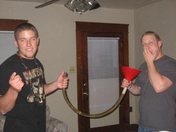 Two guys holding a beer funnel with a tube connecting them