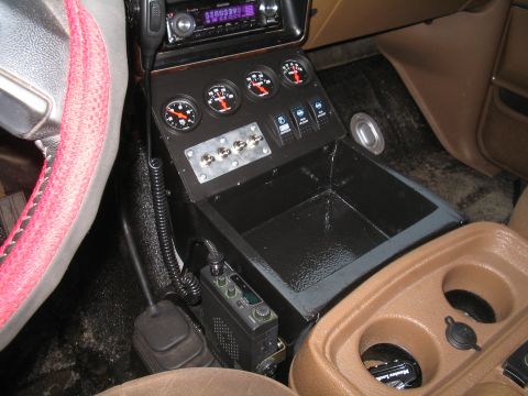1989 Ford Bronco - Custom center console features gauges, switches, and a CB radio, with a cup holder assembly visible.