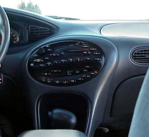 1999 Ford Taurus - Interior view of a car's dashboard, showing the center console with radio and climate controls.
