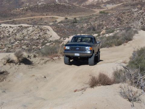 1995 Ford Bronco - This 1995 Ford Bronco navigates a challenging dirt path in a dry, hilly landscape.