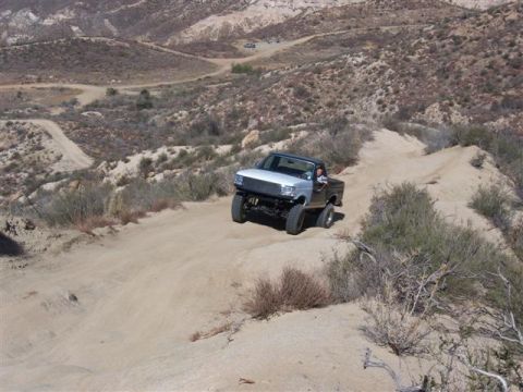 1995 Ford Bronco - This 1995 Ford Bronco navigates a challenging dirt path in a , mountainous terrain.