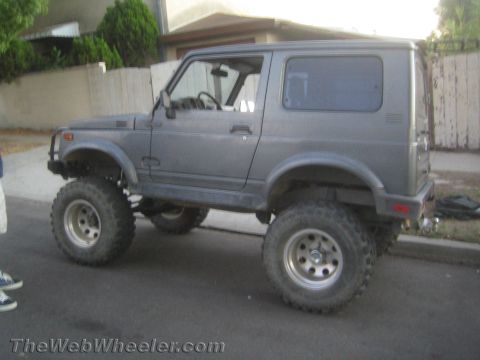 1987 Suzuki Samurai - This lifted Suzuki Samurai is parked on a residential street, showing off its off-road tires.