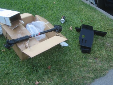 1987 Suzuki Samurai - A driveshaft and differential are laid out on the grass next to a cardboard box.