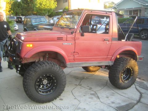 1987 Suzuki Samurai - This red Suzuki Samurai has been modified with large off-road tires and a bull bar, suggesting it is not a stock 1987 model.