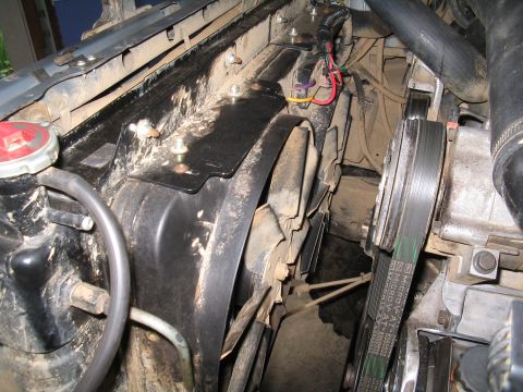 1989 Ford Bronco - The engine bay features an electric fan assembly and drive belts, with visible wiring and hoses.