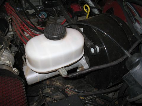 1989 Ford Bronco - Close-up view of a vehicle's brake booster and master cylinder assembly.